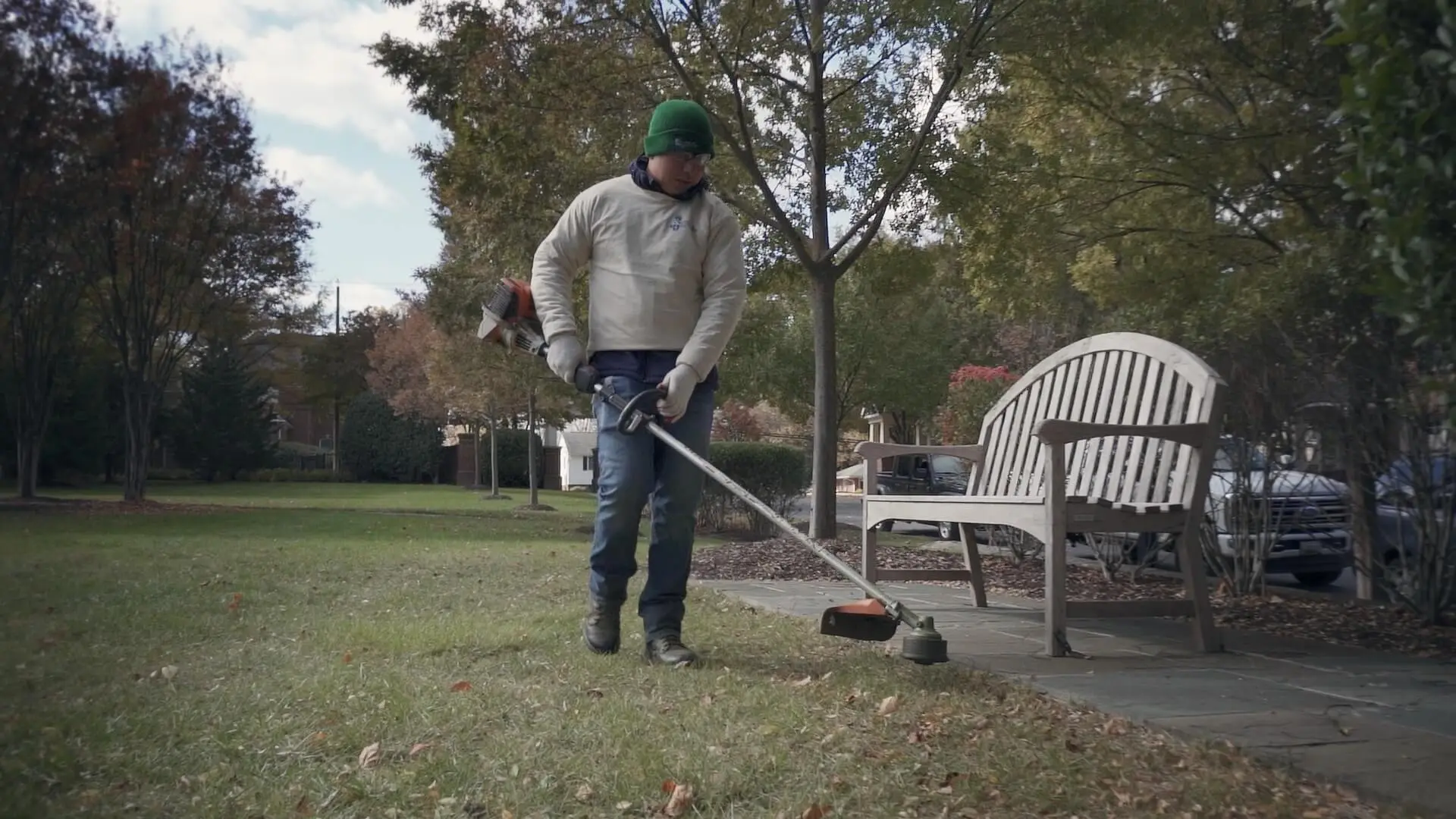 Worker string-trimming grass on a commercial property in Alexandria, VA.