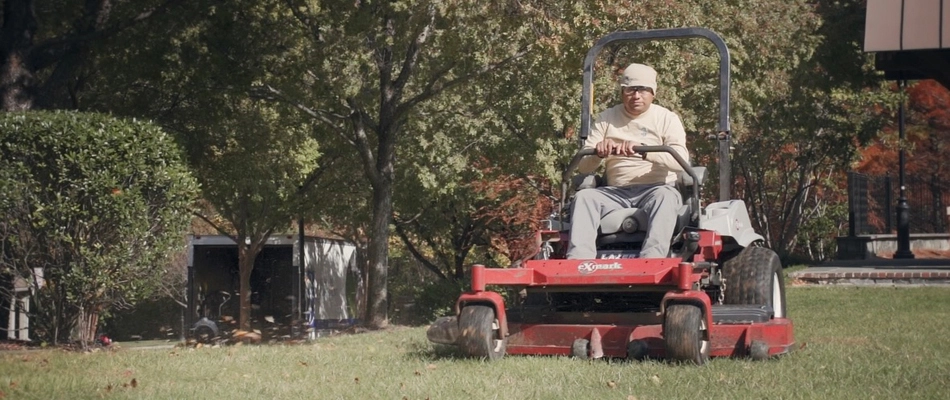 Worker in Alexandria, VA, mowing a lawn on a commercial property.