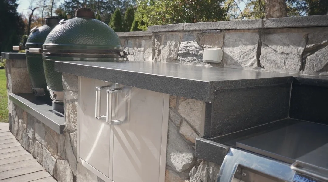 Residential outdoor living space with custom kitchen, patio, and retaining wall in Arlington, %state%%.